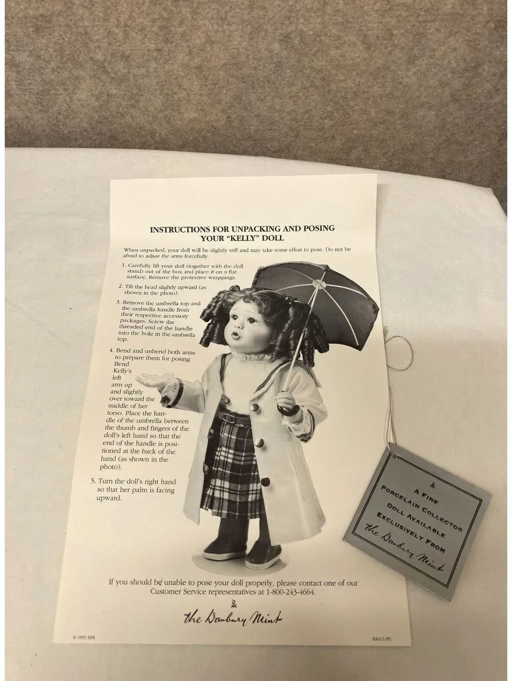 The Danbury Mint 'Kelly' Porcelain Doll with Blue Umbrella and Yellow Raincoat